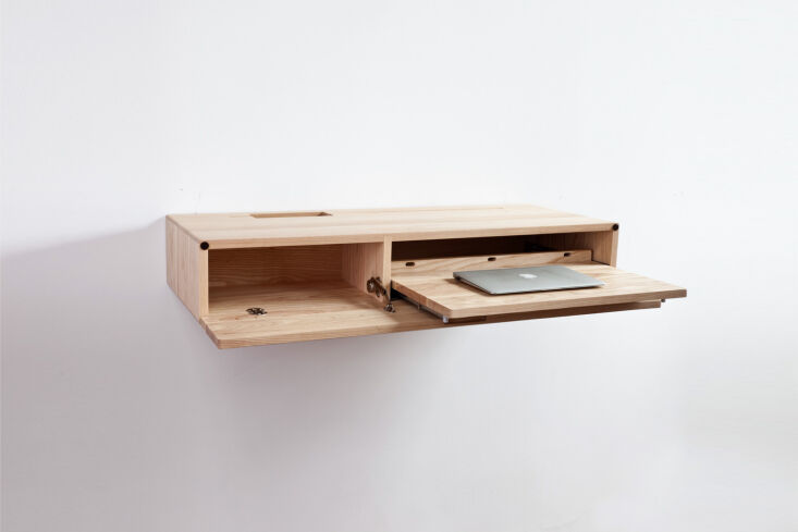 A sleek, minimal wooden ledge desk mounted to a wall.