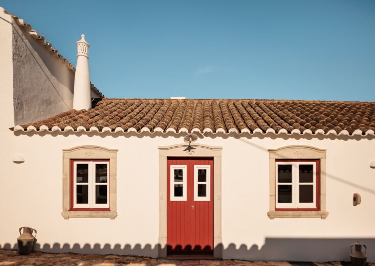 The Flower House cottage with its own covered terrace and a cobblestone alleyway.