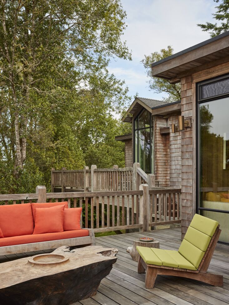 A redwood burl outdoor table on a wooden deck overlooking the forest.
