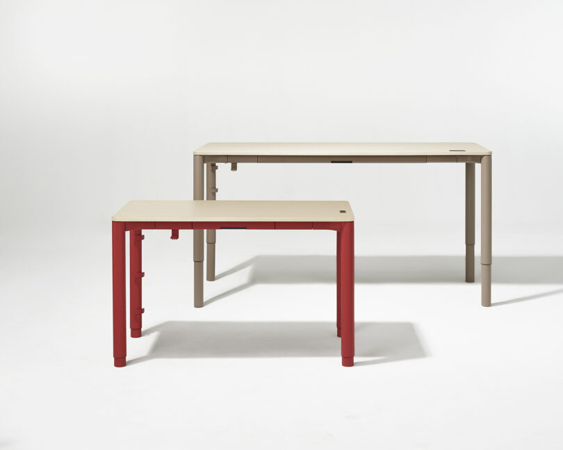 Two Spout Sit-to-Stand tables side-by-side on a white background showing the 4-leg frame.