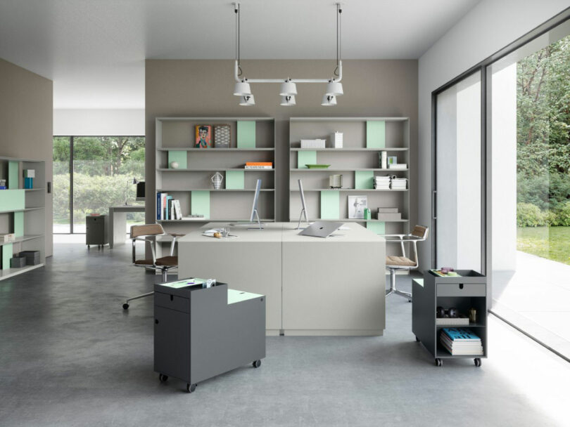 A bright, modern minimalist office interior with open shelving and rolling storage units.