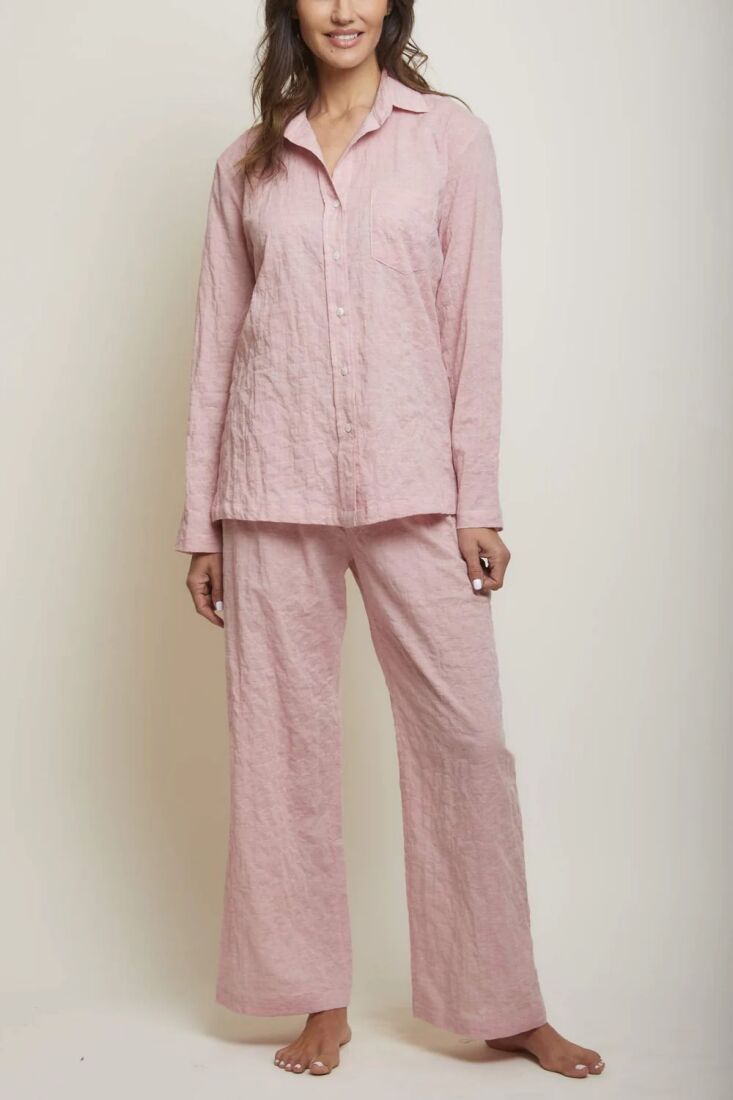 A model wearing a light pink organic Japanese cotton pajama set with delicate button detailing.