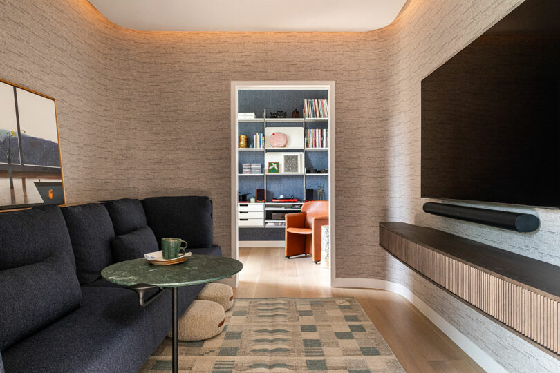 Modern living room with a dark sectional sofa and a statement green marble coffee table.