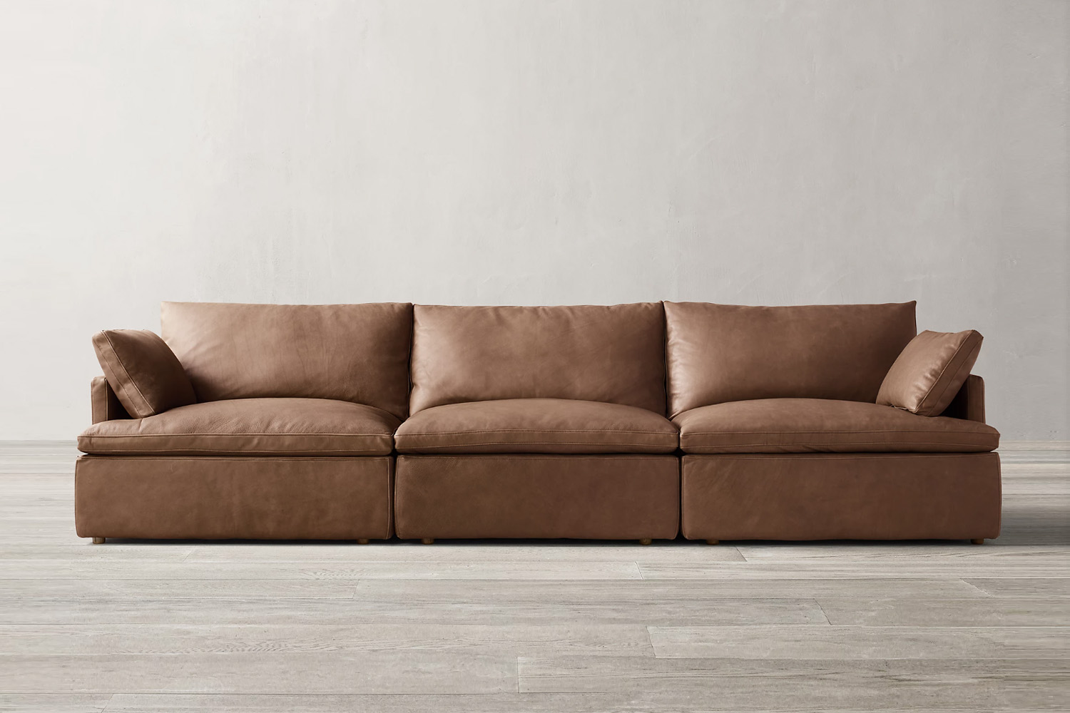 A white-toned RH Cloud Track Arm Modular Leather Sofa in a spacious living room.
