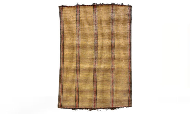 A large Tuareg rug with intricate woven patterns and earthy tones.