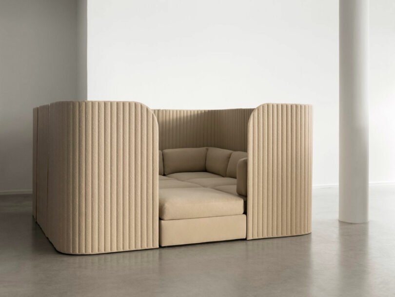 A private beige seating pod with high ribbed walls designed for acoustic privacy.