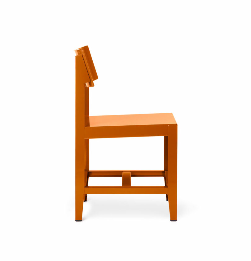 Side profile of an orange Bishop Chair showing its slim 1mm steel silhouette and minimalist structure.