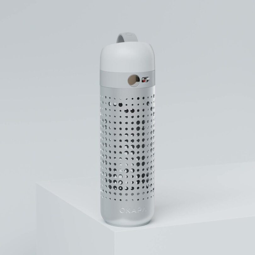 A white and silver reusable water bottle with a perforated design and a round viewing window.