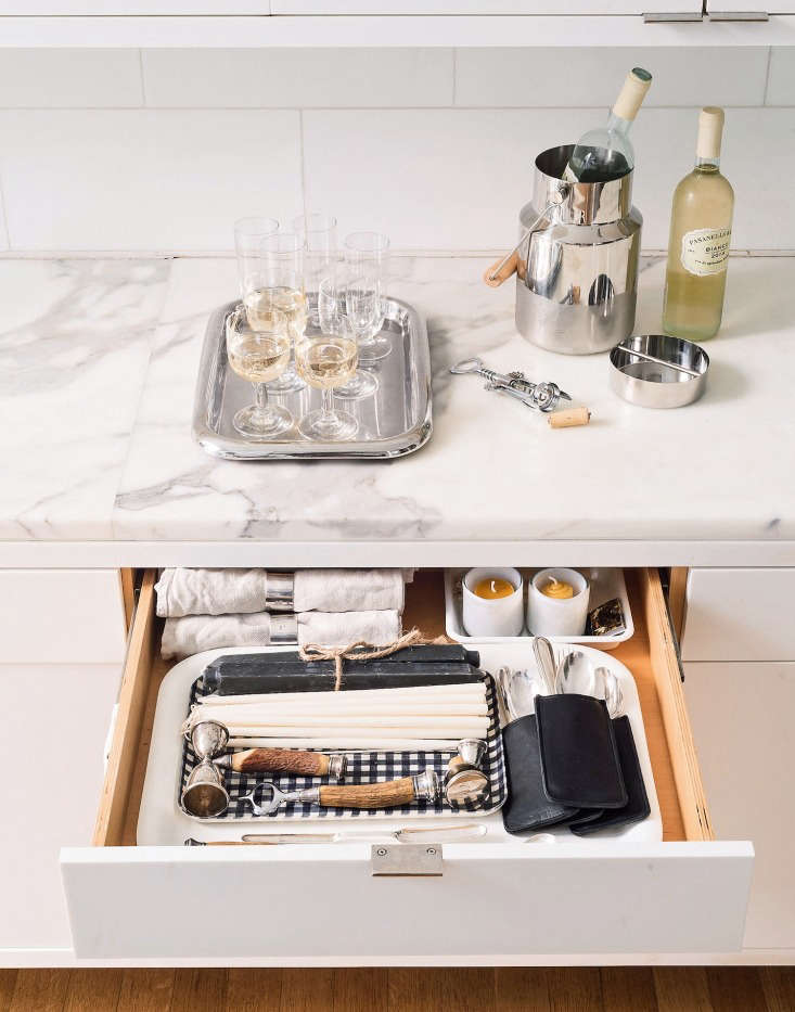 An open cabinet showing neatly organized and visible dinnerware and party supplies.