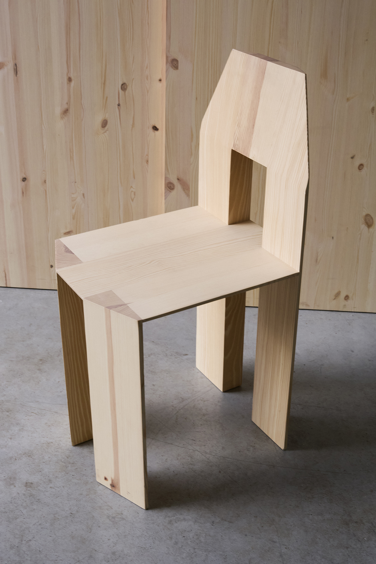 Close-up of the Min Chair's backrest showing the square cutout and pinewood grain.