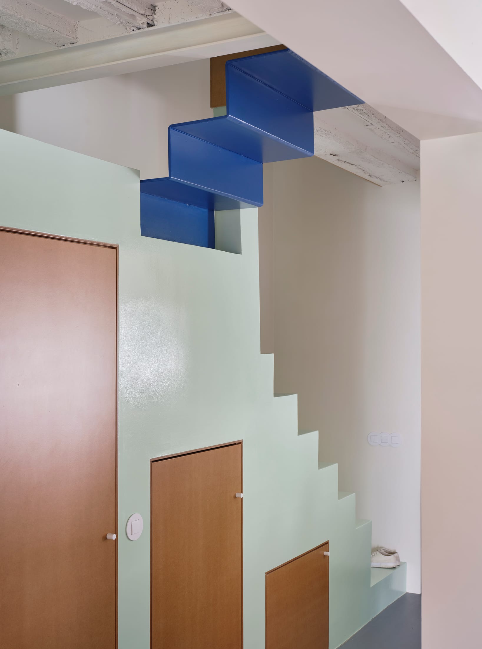 View from the ground floor looking up toward the mezzanine, showing the gap between the green volume and the original ceiling.