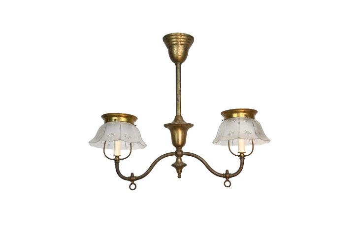 An antique chandelier converted from gas to electric hanging in a kitchen.