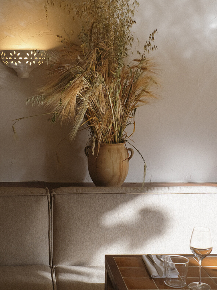 A collection of design elements including glazed yellow tiles, ceramic objects, and plaster surfaces.