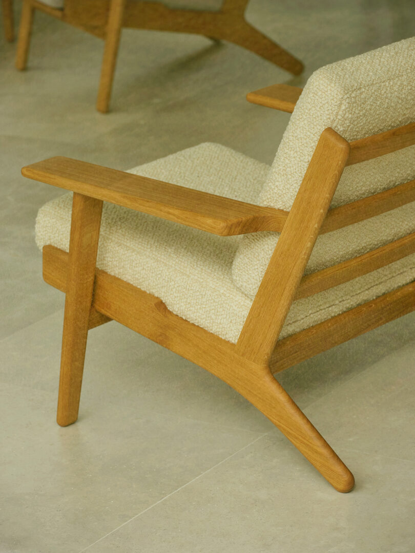 Rear view of a CH290 wooden armchair showing the signature angled leg structure and joinery.