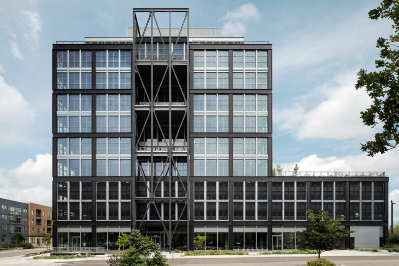 A wide shot of the multi-story Steel House office building with its distinctive black steel frame and glass facade.