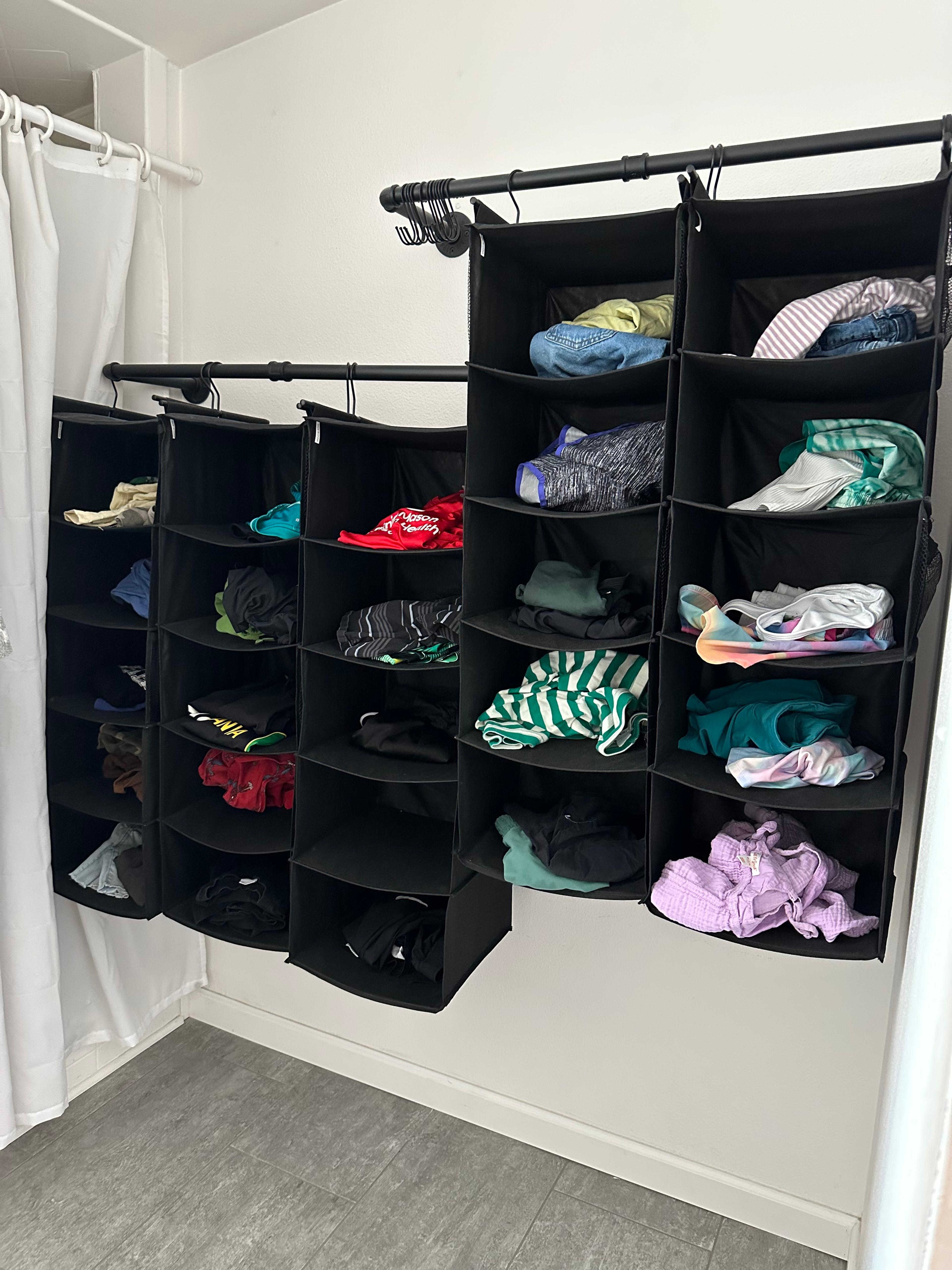 A close-up of folded laundry being placed into a shoe organizer pocket.