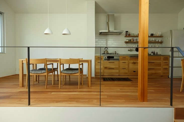 A neutral-toned kitchen and dining area featuring custom-designed Japanese wood furniture.