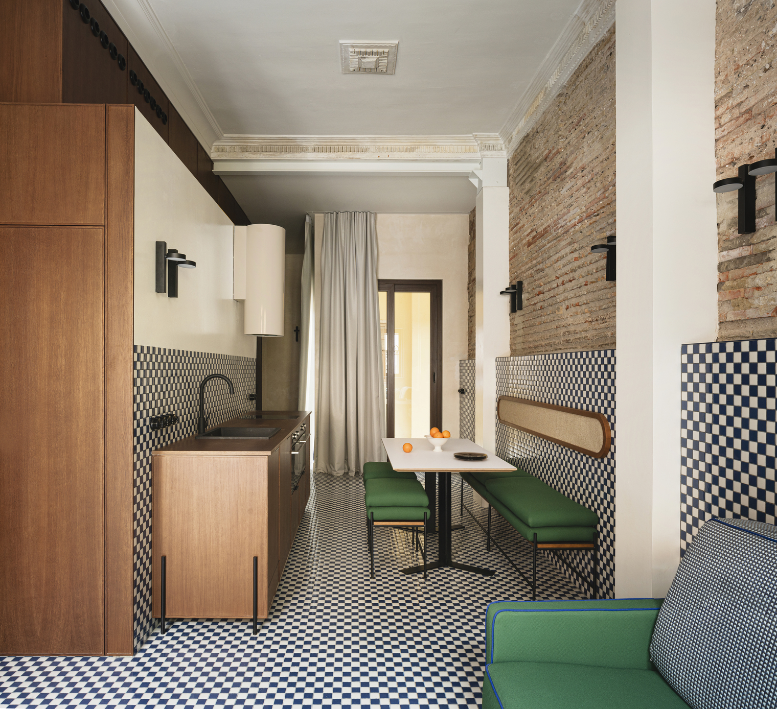 Living area with custom metal and wood benches and a view toward an internal courtyard.