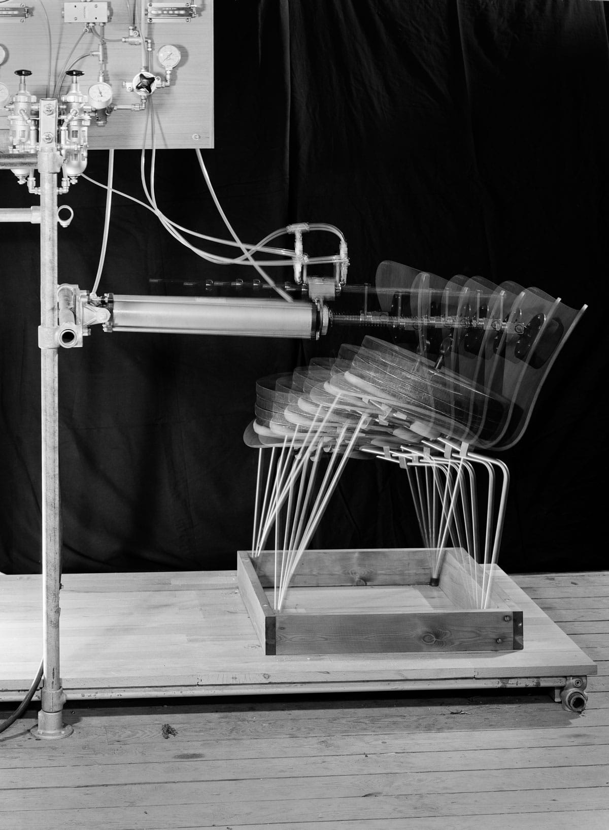A vintage mechanical testing machine putting pressure on a Series 7 chair shell.