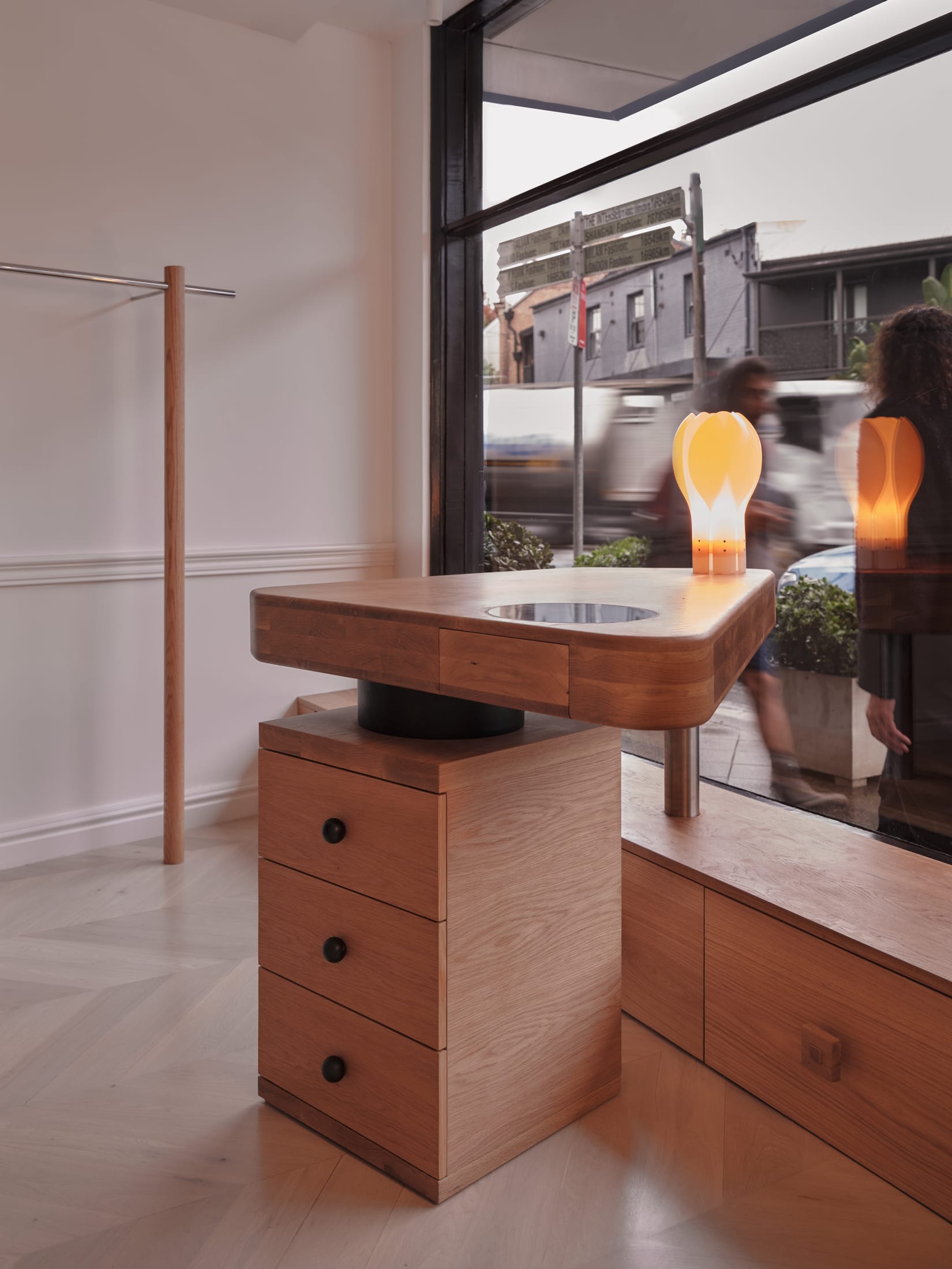 Close-up detail of smooth oak timber textures and soft fabric layers within the boutique.