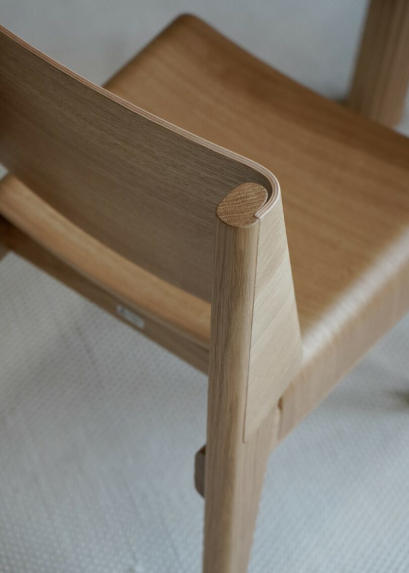 A close-up view of the natural finish wooden chair backrest and smooth joinery.