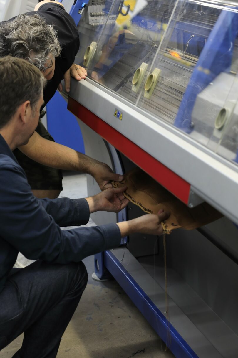 Technicians monitoring the Isomi Knit One 3D-knitting industrial machine.