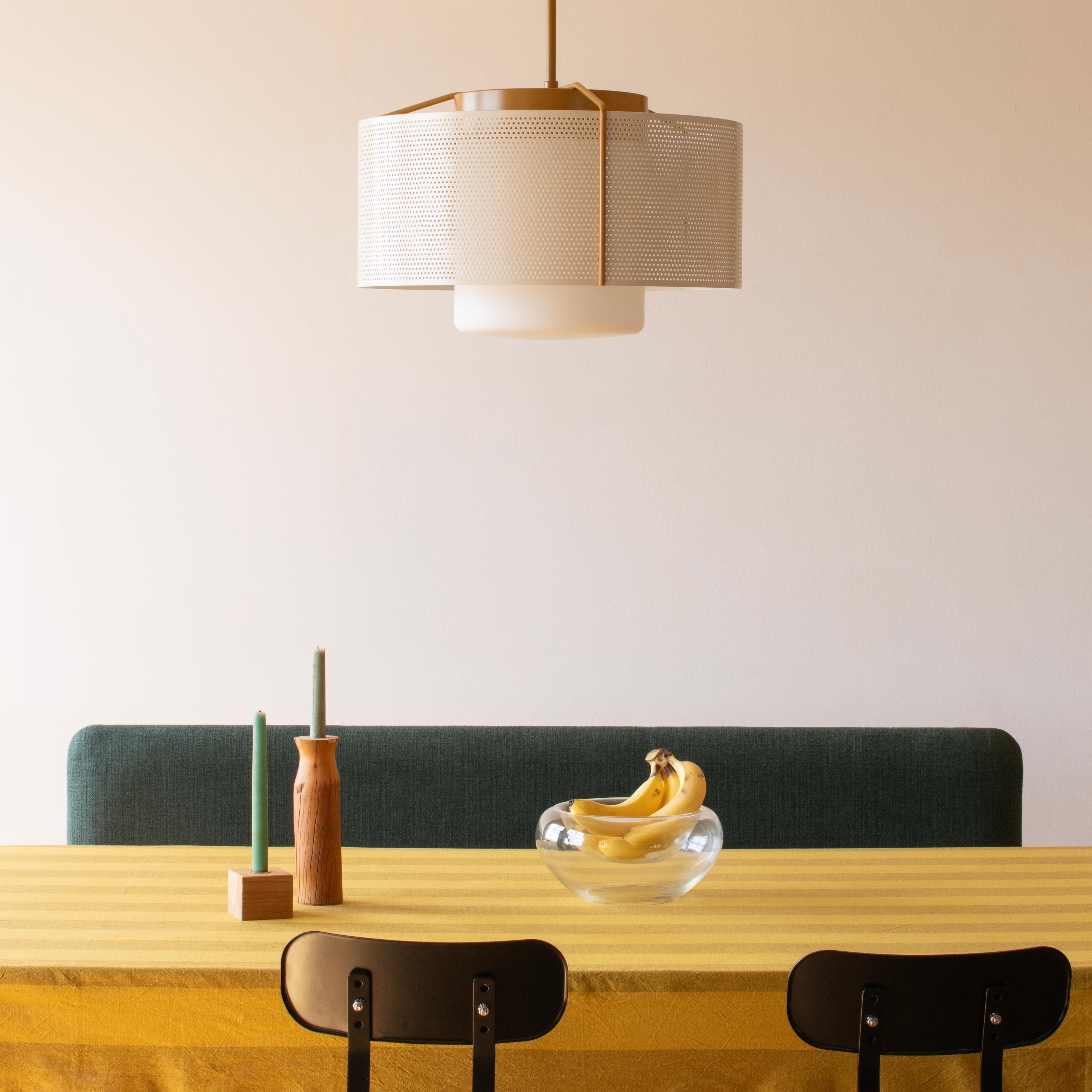 A Schoolhouse Electric Swell pendant hanging elegantly from a ceiling hook.