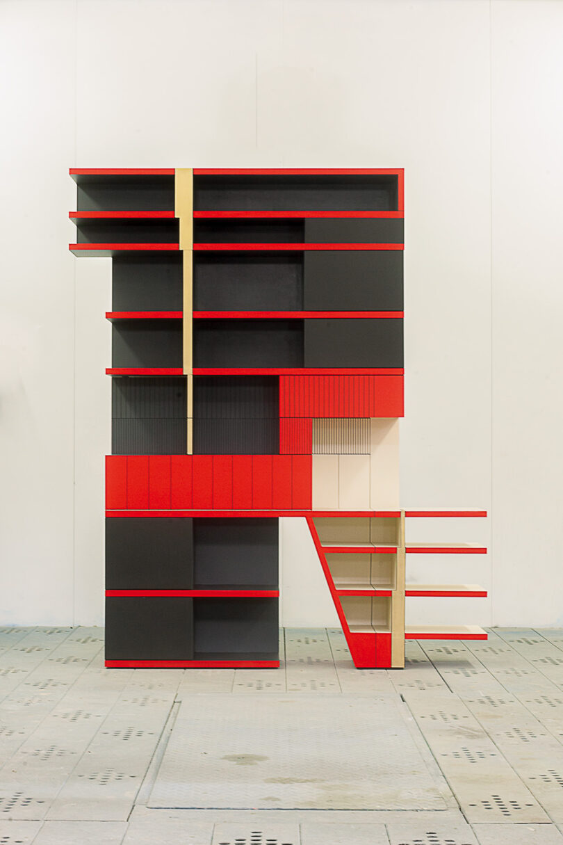 Modern shelving unit with red, black, and beige geometric sections inspired by Memphis design.