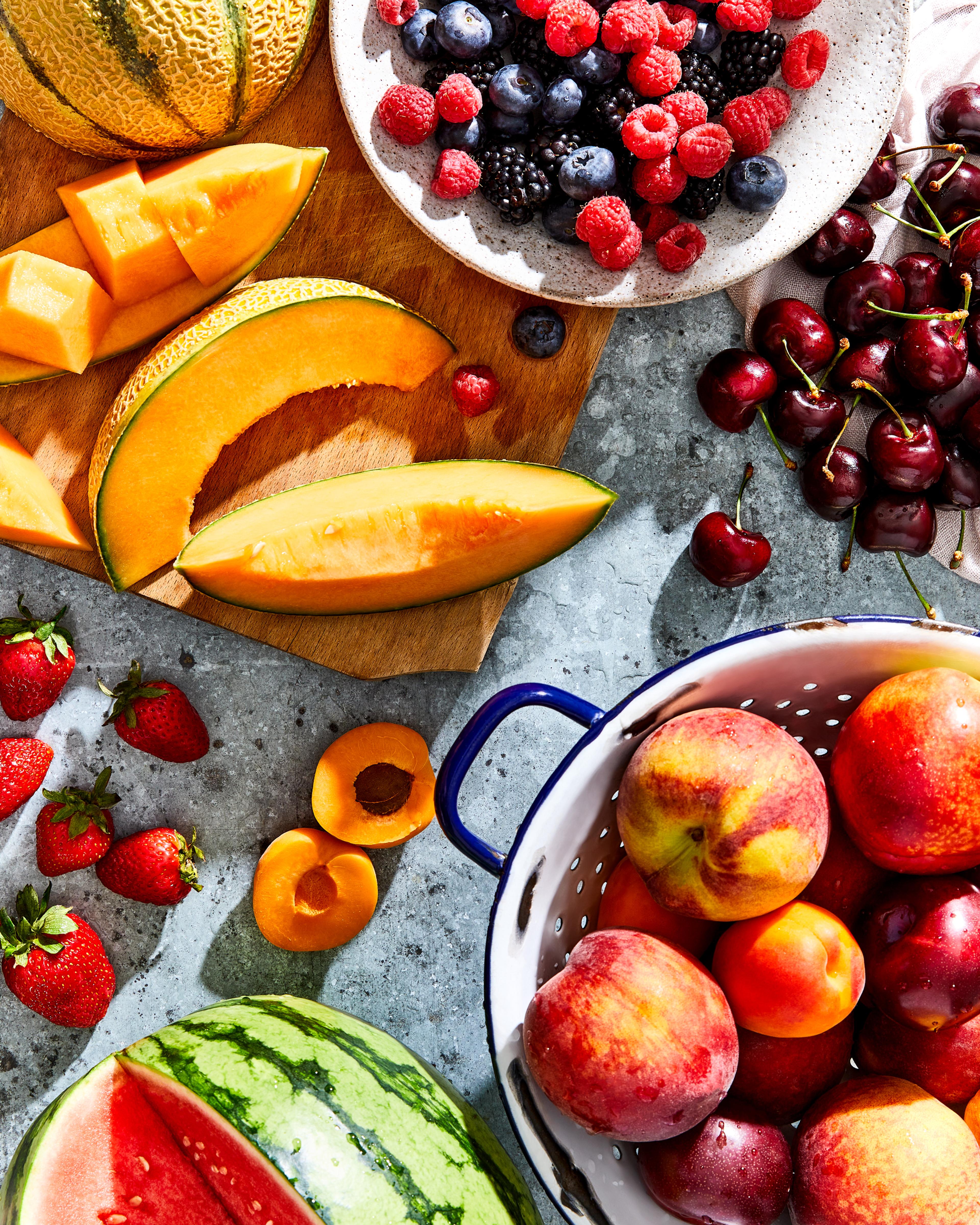 A vibrant summer fruit and hosting spread on a sunlit table.