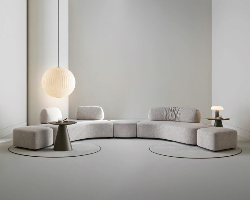 A contemporary lounge space featuring a modular gray sectional and minimalist lighting.