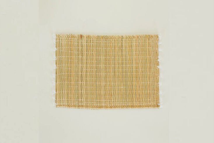 Tasseled woven placemats made in Morocco displayed in an overlapping stack.