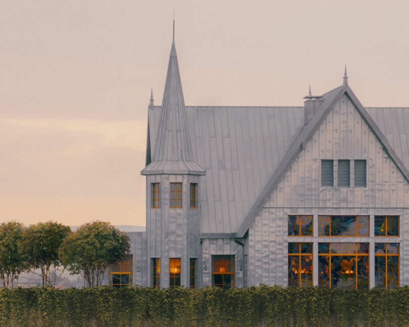 Exterior view of Maison Heler showing the modern metal siding and the traditional pointed turret design.