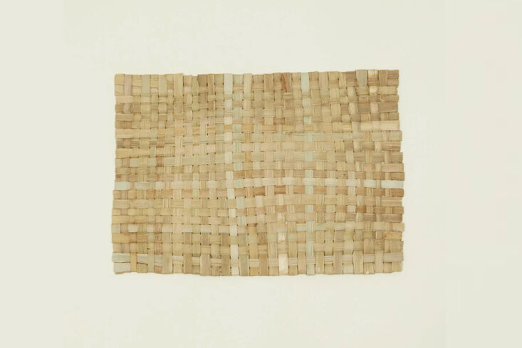 A close-up of a handwoven wicker placemat created by Itza Wood for Hawkins New York.