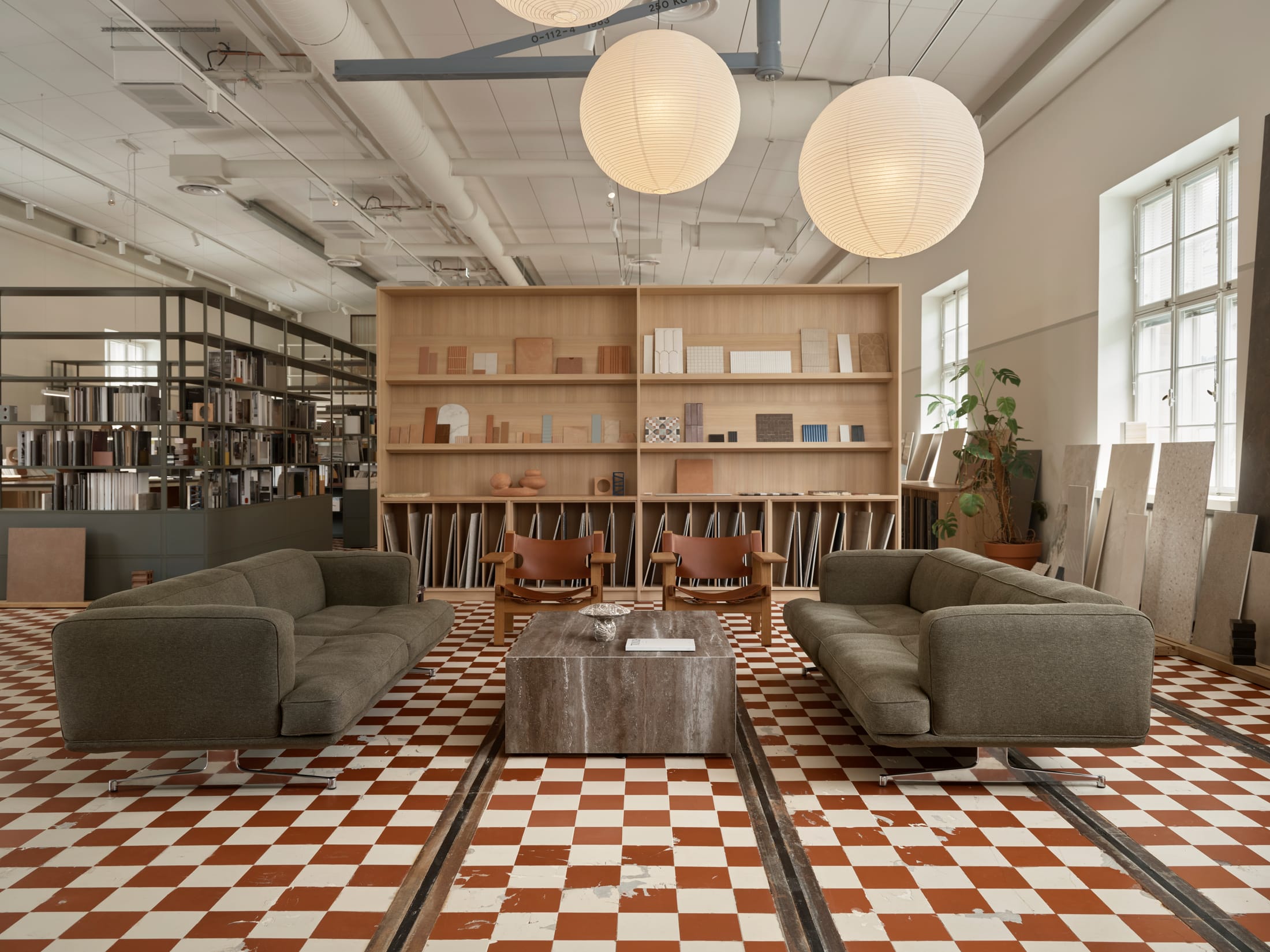 Interior view showing high ceilings, original structural elements, and modern minimalist furniture.