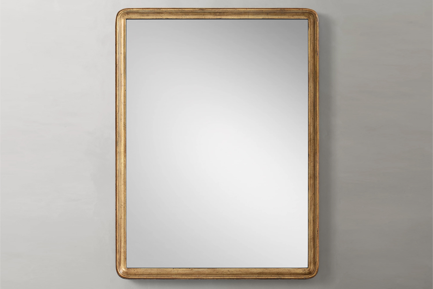 A gilded antique mirror sitting atop a marble fireplace mantel.