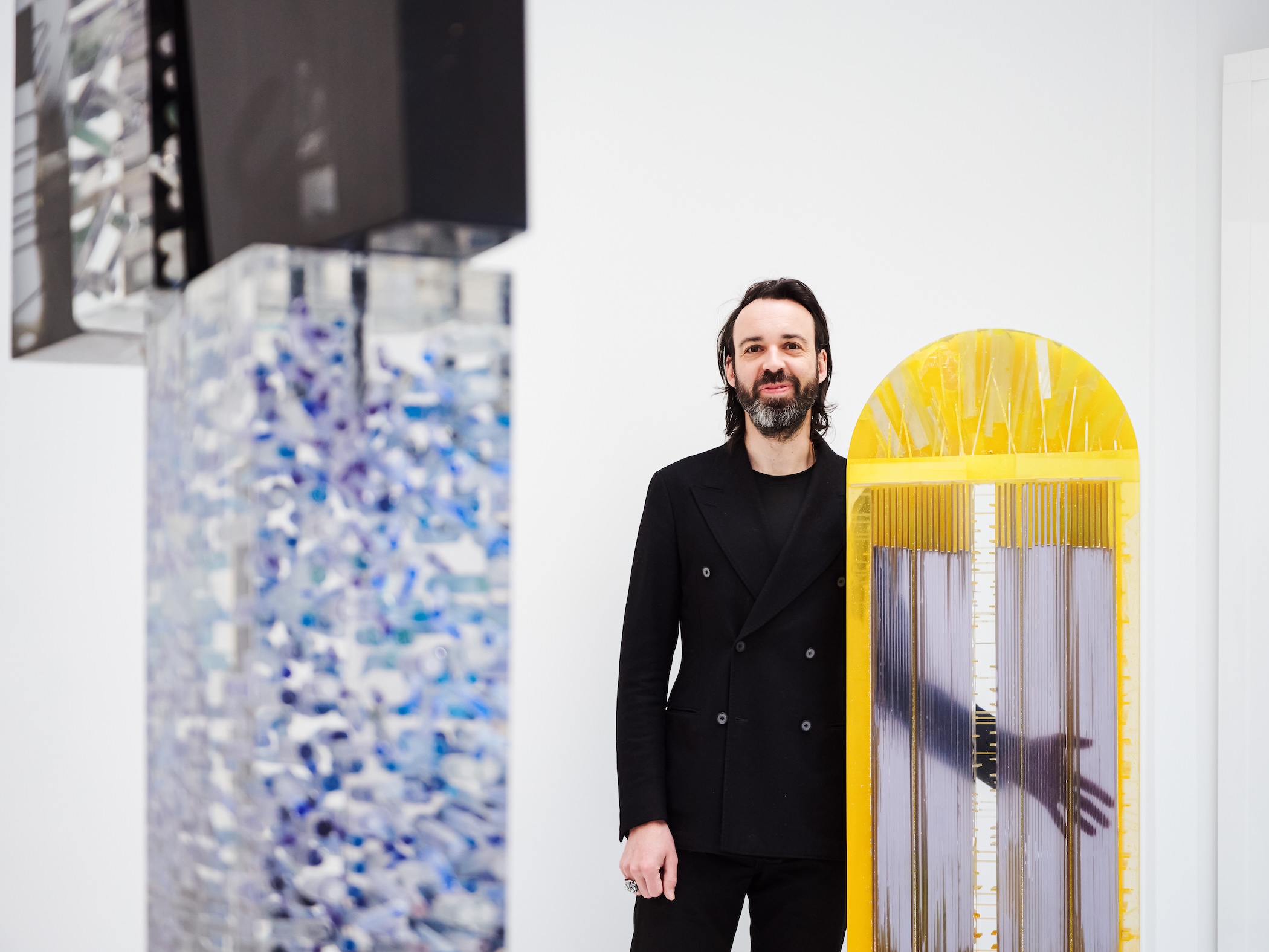 Close-up of a translucent geometric resin sculpture by Monique Rozanès showing light refraction.