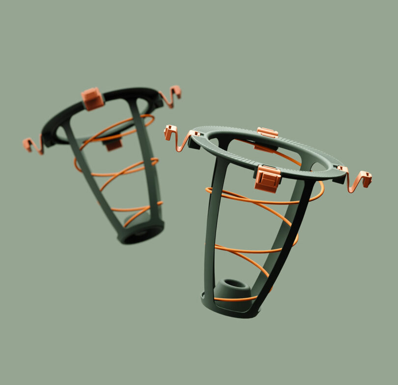 A close-up of two individual orange spring modules with square connector bases.