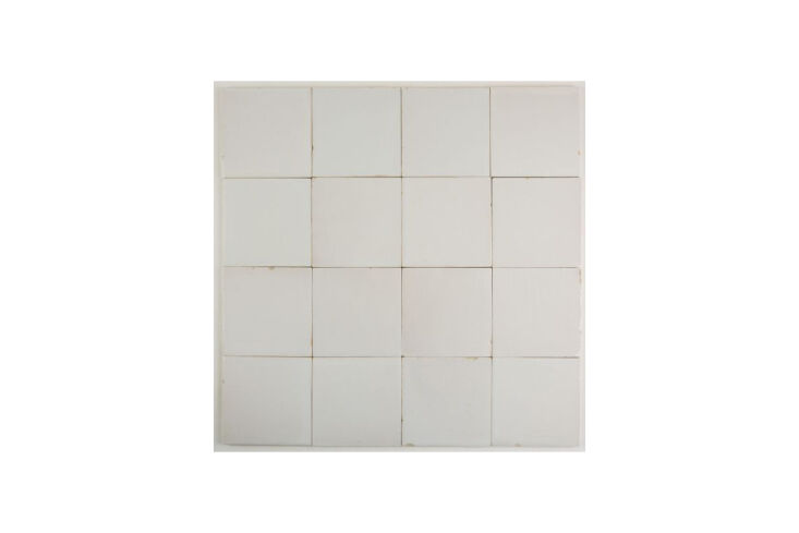 White stucco backsplash tiles with a matte, unfinished texture in a gridded pattern.