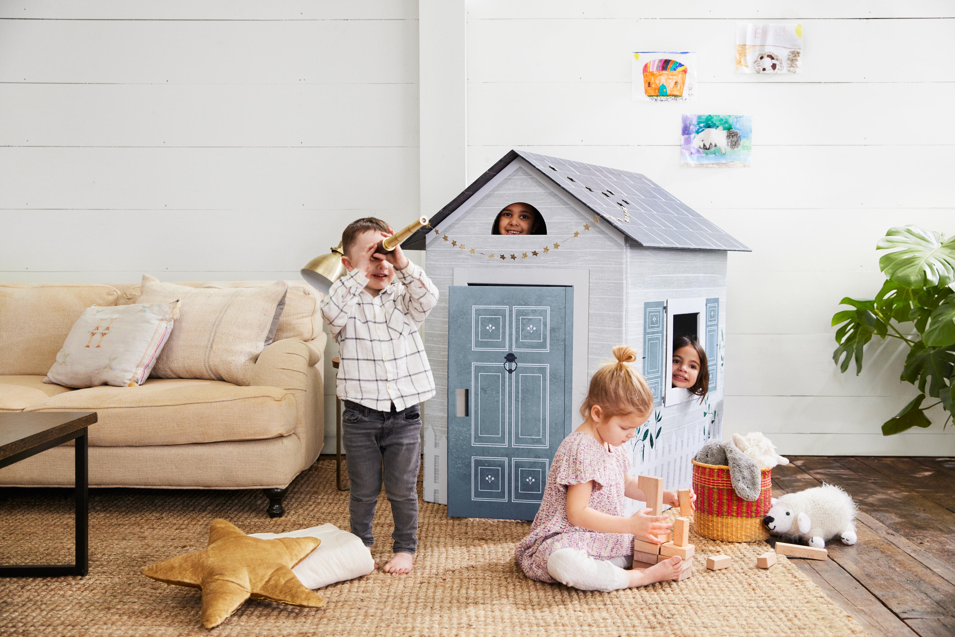 A sustainable, plastic-free cardboard playhouse designed to look like a modern farmhouse.