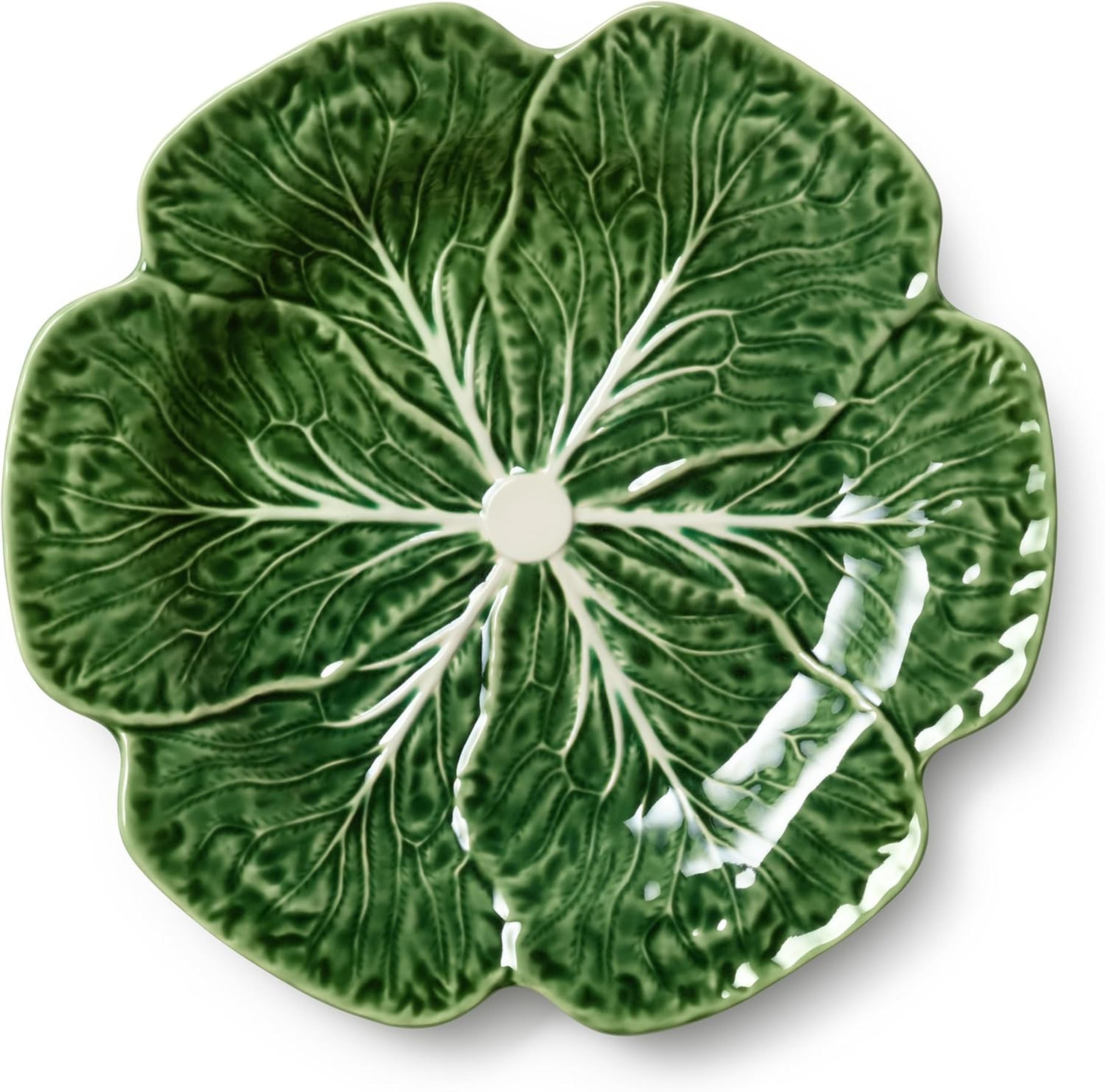 Green cabbage-shaped ceramic serving bowl on a white surface.