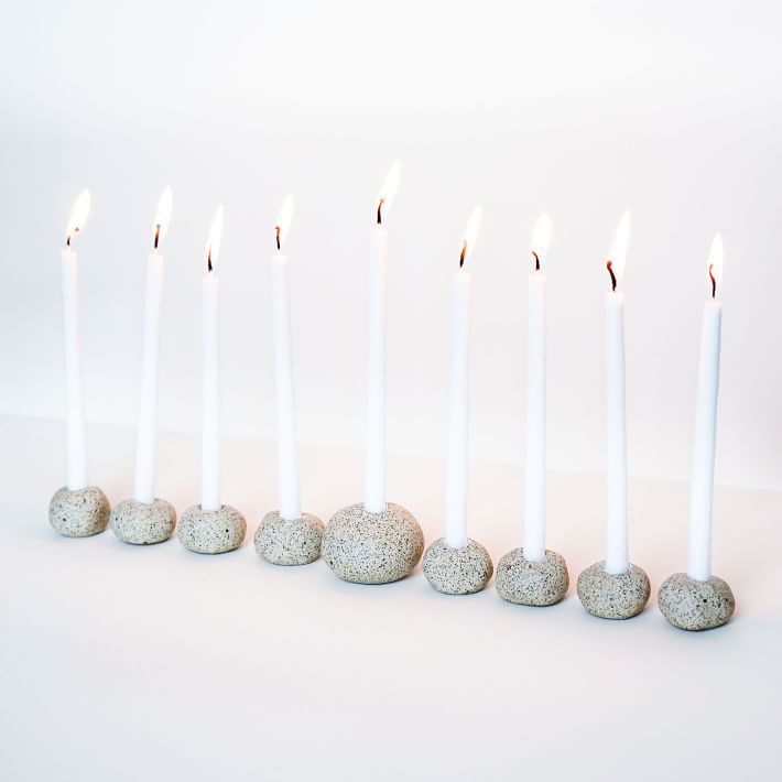 Individual speckled clay candle holders arranged in a group to form a modular menorah.