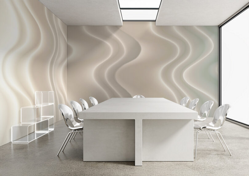 A brightly lit conference room with a large white table and wavy patterned walls.