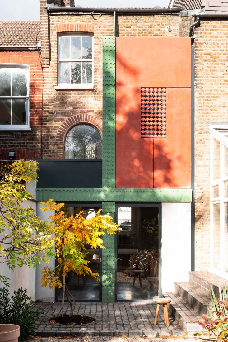 A juxtaposition of the traditional 1892 Victorian brick facade and the modern green and salmon pigmented concrete rear extension.