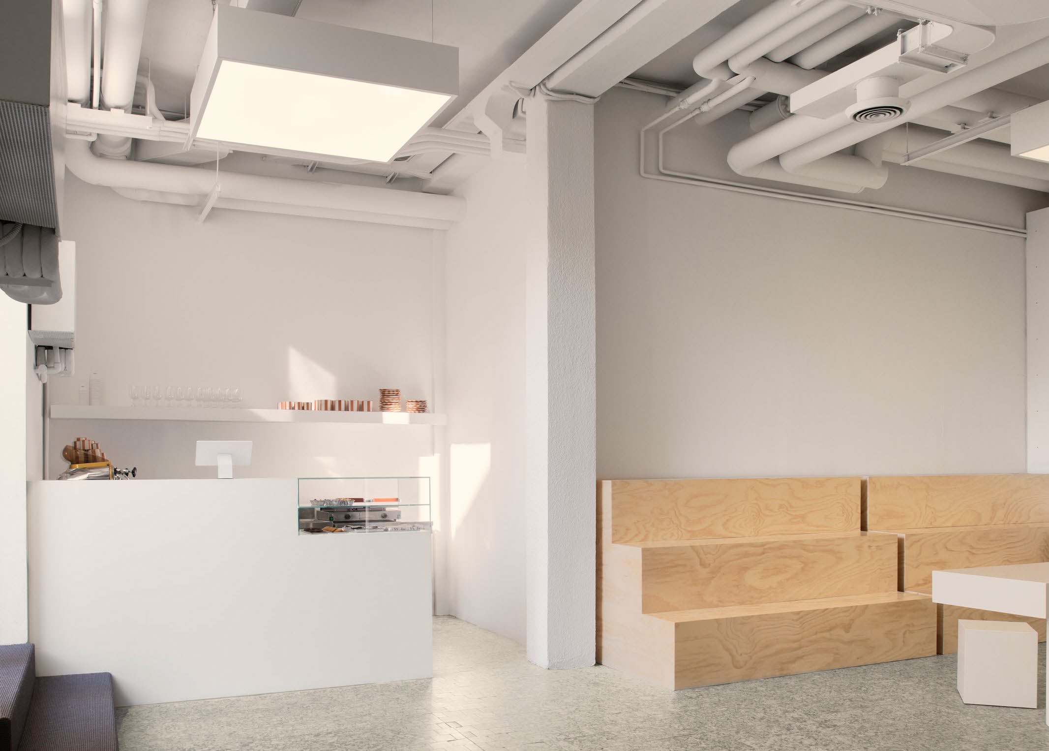 Wide interior view of the Sunnei Milan flagship store showing the minimalist white design.