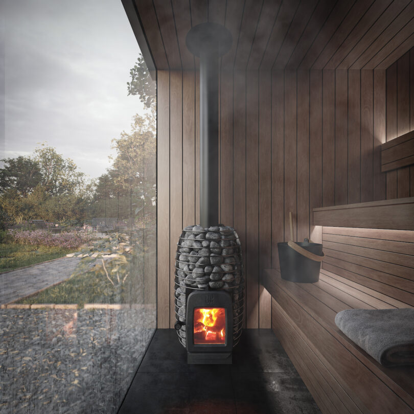 A wood-burning sauna stove with a visible fire and sauna accessories on a bench.