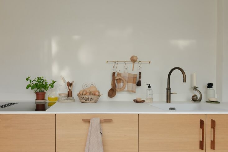 Close-up of light oak Veda kitchen cabinets from Kvik with custom wooden handles.
