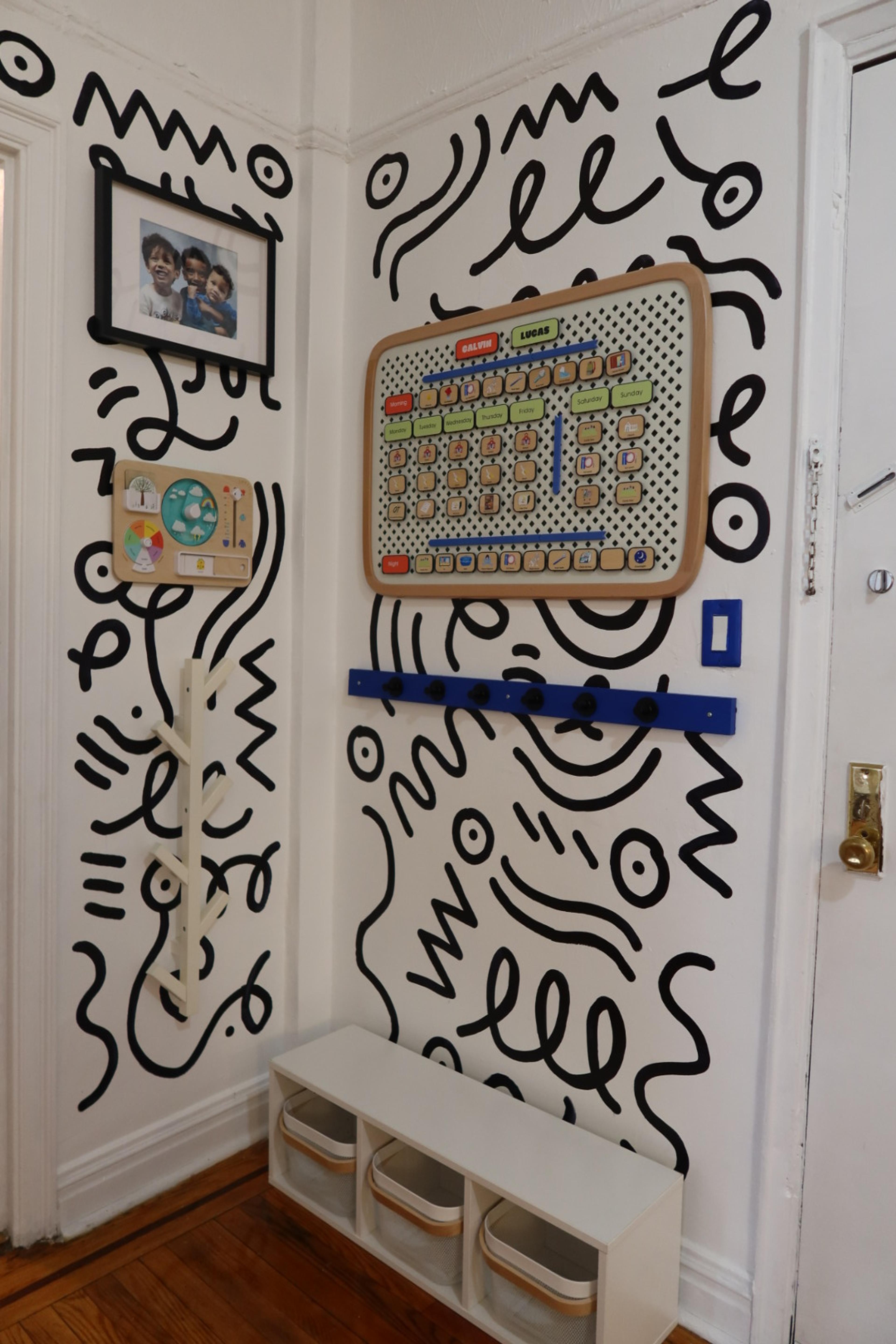 A colorful visual routine board and calendar from Charmspring mounted on a wall.