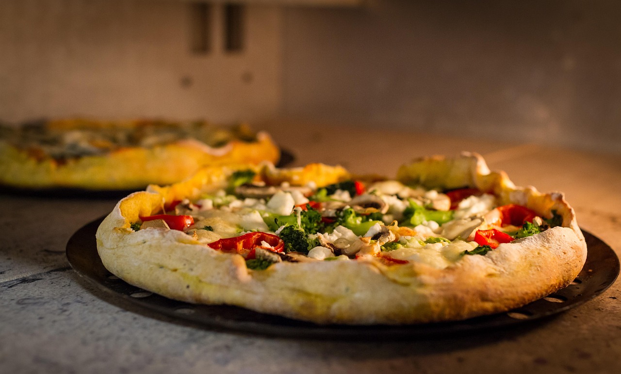 Stone outdoor pizza oven with a wood fire burning inside