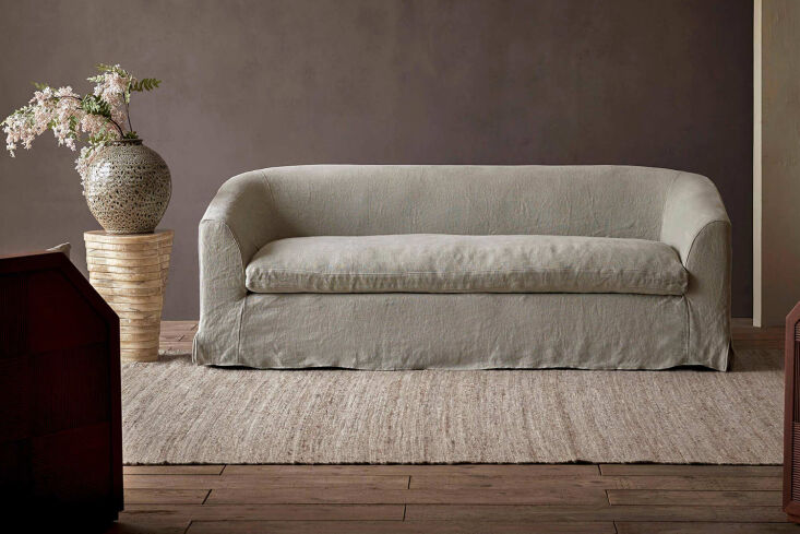 The Six Penny Ziki Sofa featuring sloped arms and a light-colored upholstery.