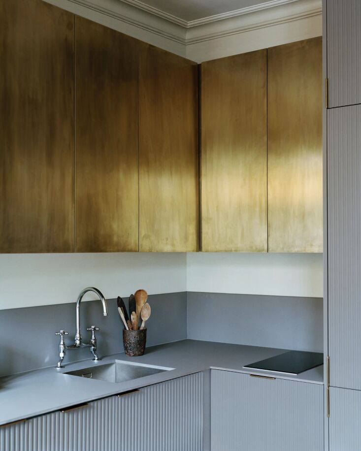 Modern kitchen with brass and grey-blue custom fronts on IKEA cabinet frames.